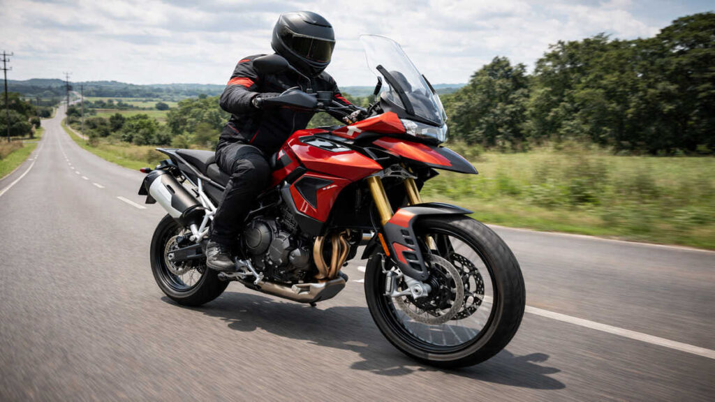 Rider on Triumph Tiger 900 motorcycle riding on open road in daylight
