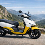 White and yellow Ather Rizta electric scooter parked on a mountain road